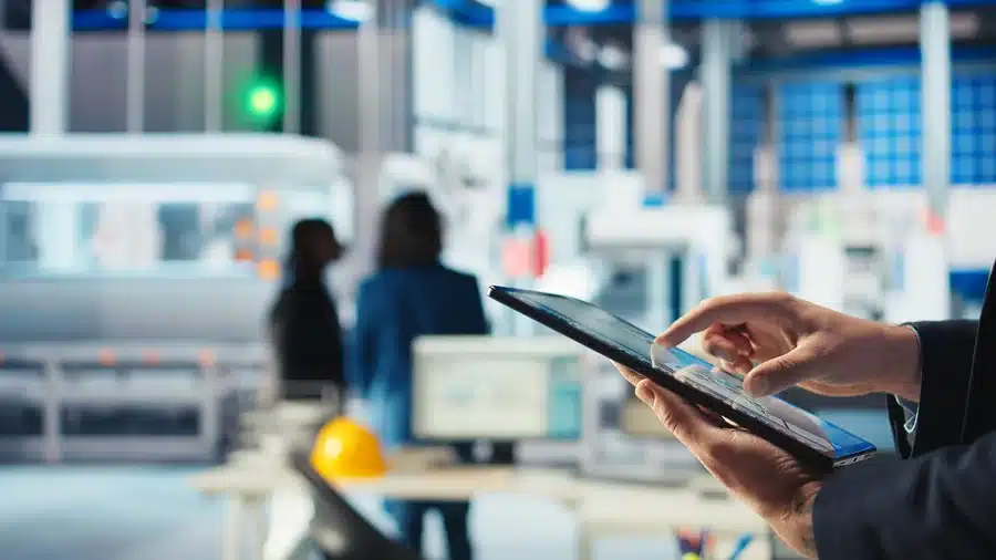 Engineer in photovoltaics factory using tracking software on tablet to diagnose malfunctioning systems